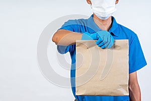 Delivery man with rubber gloves holding paper bag