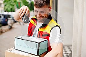 Delivery man scanning boxes a barcode packages with a handheld barcode scanner