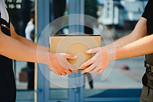 Delivery man service with boxes in hands standing in front of Customer`s house doors