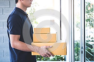 Delivery man standing with parcels in hands outdoors waiting homeowner open door, Home delivery service and working with service