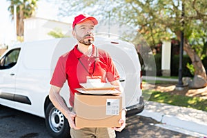 Delivery man in a uniform holding a small package