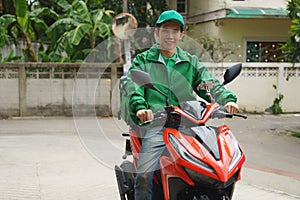 Delivery man in uniform ride motorbike delivery food to customer home