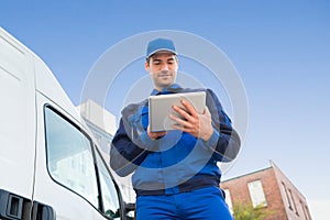Delivery Man Using Digital Tablet By Truck Against Sky