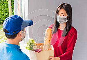 Delivery man wear protective face mask making grocery giving fresh food to woman customer