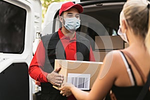 Delivery man wearing face protective mask to avoid corona virus spread - Young woman receiving an online order package