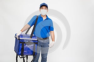Delivery man wearing protective medical mask for prevent virus and holding blue delivery food box  on white background.