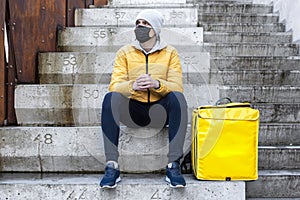 Delivery man at winter with yellow backpack