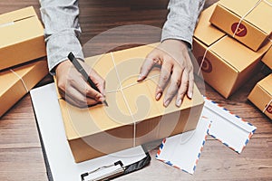 Delivery man writing on cardboard box for delivery