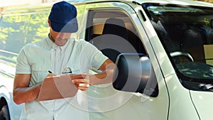 Delivery man writing on clipboard