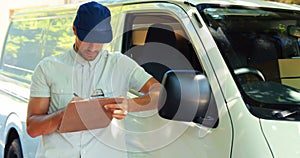 Delivery man writing on clipboard