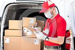 Delivery man writing a customer information before delivering a parcel