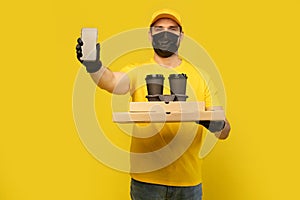 Delivery man in yellow t-shirt, mask, gloves isolated. Guy hold takeaway cup of coffee. Coronavirus 2019-ncov concept