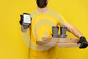 Delivery man in yellow t-shirt, mask, gloves isolated. Guy hold takeaway cup of coffee. Coronavirus 2019-ncov concept