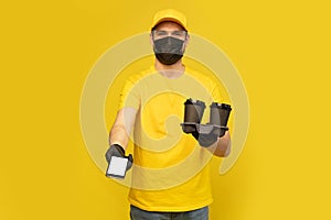 Delivery man in yellow t-shirt, mask, gloves isolated. Guy hold takeaway cup of coffee. Coronavirus 2019-ncov concept