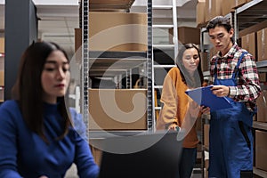 Delivery managers analyzing customer orders list clipboard in warehouse