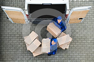 Delivery Men Carrying Cardboard Boxes Outside Truck