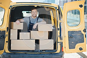 Delivery men unloading moving boxes from car