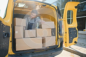 Delivery men unloading moving boxes from car