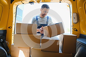 Delivery men unloading moving boxes from car