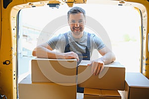 Delivery men unloading moving boxes from car