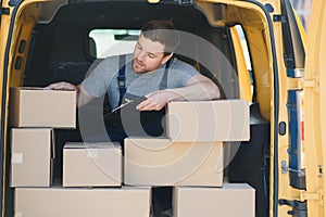 Delivery men unloading moving boxes from car