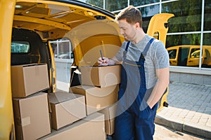 Delivery men unloading moving boxes from car