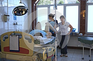 At the delivery room. Woman giving birth lying in the chair, doctors ready to deliver baby