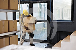 Delivery service african american loader carrying heave cardboard boxes