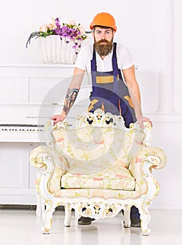 Delivery service concept. Courier delivers furniture in case of move out, relocation. Man with beard, worker in overalls