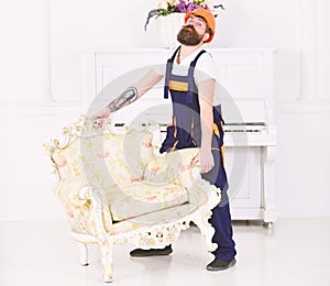 Delivery service concept. Courier delivers furniture in case of move out, relocation. Man with beard, worker in overalls