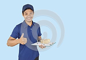 Delivery service concept.  Delivery man holding box and showing like on blue background