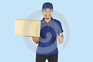 Delivery service concept.  Delivery man holding box and showing like on blue background