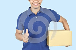 Delivery service concept.  Delivery man holding box and showing like on blue background