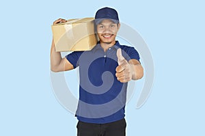 Delivery service concept.  Delivery man holding box and showing like on blue background