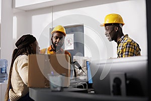 Delivery service employees discussing packages storing at warehouse reception