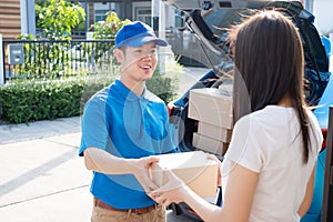 Delivery service male in uniform give cardboard box package to receiver customer client front home