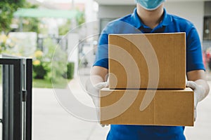 Delivery service man in blue uniform waiting for sending parcel post box to customer at door home