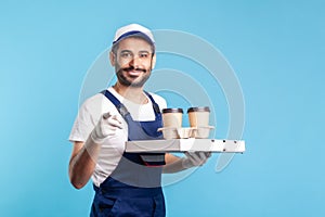 Delivery service. Smiling happy courier in overalls holding coffee, pizza box, wearing safety gloves
