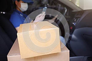 Delivery services courier during the Coronavirus COVID-19 pandemic, cardboard boxes on delivery van seat with courier driver in