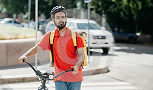 Delivery to home or office. Young man in protective helmet with backpack with bicycle looking for the address of client