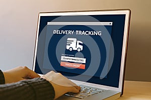 Delivery tracking concept on laptop computer screen on wooden ta photo