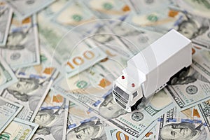 Delivery truck on hundred dollar bills banknotes. Background of moving or trucking concept