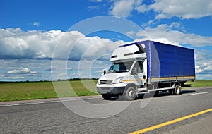 Delivery truck with white cabin and blue trailer