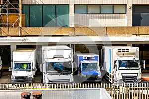 Delivery Vehicles Lined Up Outside A Facility As They Get Loaded or Unloaded photo