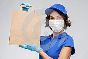 Delivery woman in face mask with food in paper bag