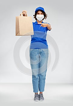 Delivery woman in face mask with food in paper bag