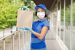 Delivery woman in face mask with food in paper bag