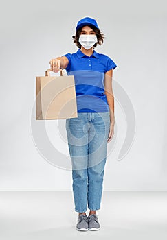 Delivery woman in face mask with food in paper bag