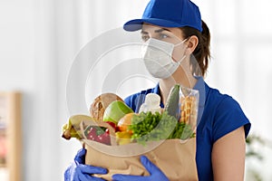 Delivery woman in face mask with food in paper bag