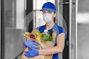 Delivery woman in face mask with food in paper bag